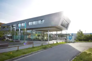 Futuristische Architektur der RMV-Mobilitätszentrale mit einer weit auskragenden, metallisch verkleideten Obergeschoss-Konstruktion.