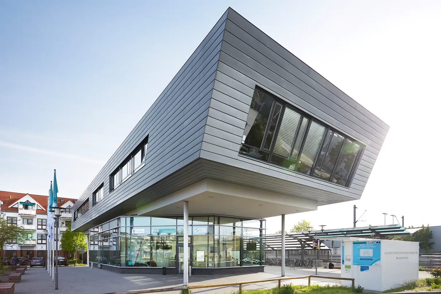 Futuristische Architektur der RMV-Mobilitätszentrale mit einer weit auskragenden, metallisch verkleideten Obergeschoss-Konstruktion.